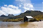 An old boathouse rests by the calm lakeside at Cradle Mountain in Australia's wild state of Tasmania.