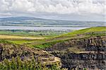 The top of the Cliffs of Moher in Ireland with a river and valley behind them