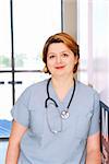 Portrait of a smiling nurse standing in a hospital corridor