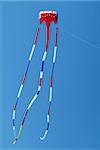 Red, white and blue kite on a blue sky background