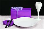 A colorful dinner table in purple with wine and gift