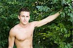 Sexy, handsome and shirtless male model in the forest
