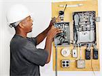 Electrician crimping a wire in an electrical panel.  Model is actual electrician performing work according to industry code and safety standards.