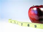 Apple on white with measuring tape signifying weight watching or weight loss