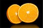 Citrus fruit  half oranges isolated over black mirror
