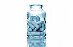 bottle of pills isolated on white background, with a blue glow