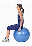 Young active woman sitting on a blue fitness ball