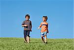 Two Boys Running Down A Hill on a Beautiful Day