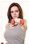 Attractive auburn hair or brunette woman with hand forward holding a small three pound weight over white