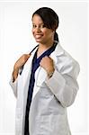 Female attractive African American doctor wearing white lab coat and a stethoscope around shoulders smiling standing on white background