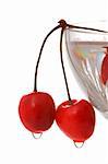 two wet cherries at the edge of a crystall vase