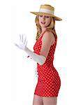 beautiful blond woman wearing tight polka dot dress and long white gloves and straw hat holding out hand to look at diamond ring standing sideways on white background