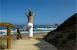 Beautiful young woman doing yoga on the beach