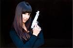 Attractive woman posing with pistol against black background