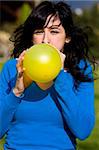 Teen inflating yellow balloon