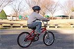 A young boy riding his bike.