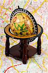 an old globe standing on a map - close up