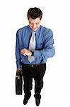Businessman holding a briefcase checks the time