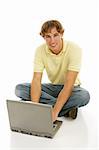 Handsome late teen man on a laptop computer.  Full body isolated on white.