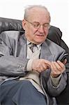 Close-up image of a senior man typing a message on his mobile phone.Shot with Canon 70-200mm f/2.8L IS USM