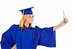 An Caucasian teenage in blue graduation gown and smiling while holding a  cell phone and taking a picture of herself.  She is on a white background.