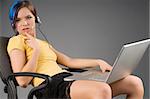 attractive girl with laptop on legs and earphone in a sexy pose