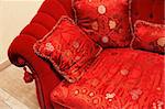 Red pillow with an ornament on a sofa