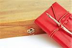 An old wood box with a calligraphy pen on top and  leather red diary  on a white background