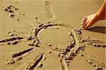 Sun drawn on sany beach. Vacations and summer concept
