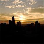 Sunset silhouetting aerial view of Charlotte, North Carolina city skyline.