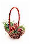 Basket with grass and four colored Easter eggs