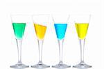 Four glasses with beverages, reflected on white background. Orange on angle. Shallow depth of field