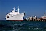 Huge white cruise ship  is docking in the greek harbour