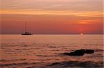 Sailing boat silhouette and sunrise - sun is just being born from the sea