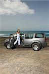Beautiful woman and her 4wd car at beach