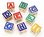 several alphabet blocks scattered on a white surface