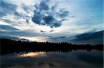 A lake in the evening with a dramtic sky with clodus