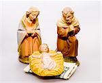 Commercialism vs Christmas, Mary and Joseph looking at baby Jesus, with money under the manger.