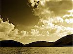 Sepia toned image of mountains lake and cloudy sky