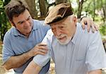 Senior man in failing health and his worried middle-aged son.  Focus on Senior man.