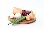 Different sorts of onions on a wooden kitchen board