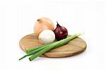Different sorts of onions on a wooden kitchen board