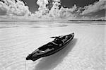 A small canoe drifting in the water under a fantastic sky. Beautiful white sands beach at Bahia Honda State Park in Florida.