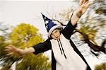 Young boy in a wizard costume with his arms outstretched