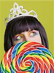 Pretty young woman with a large colorful lollipop