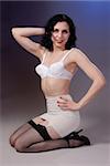 Retro fifties pin-up attractive girl in vintage bra and girdle and fishnet stockings on colorful background - pin-up concept