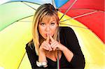 young girl gestures for silence under the umbrella