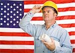 Construction worker with blueprints tipping his hardhat to the American flag.  Photographed in front of the flag, not a composite image.