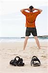 Man doing exercises on a beach in summer