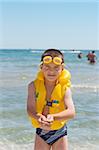 Boy with yellow safety equipment at the seaside